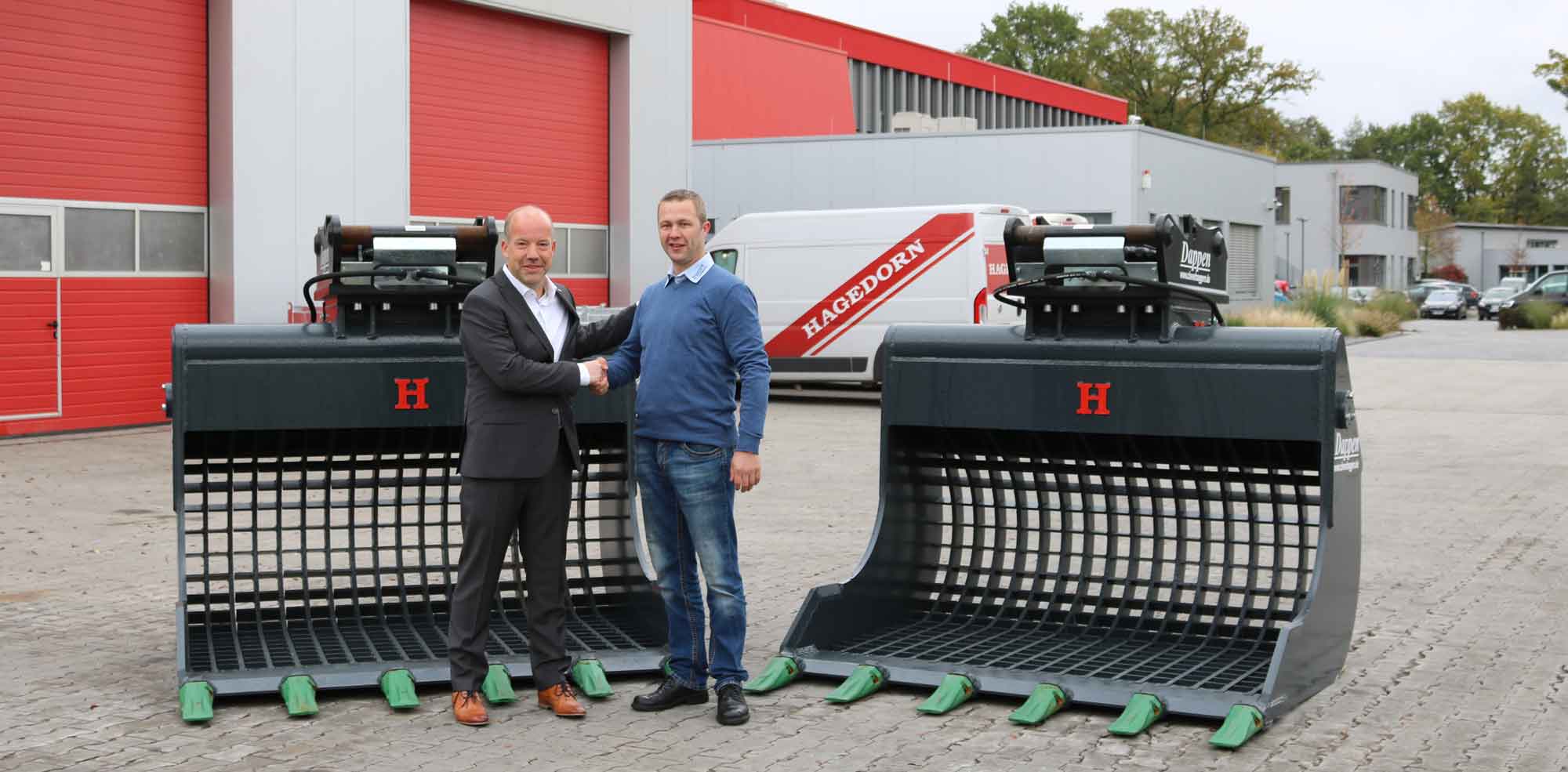 Dappen Werkzeug- und Maschinenbau | Hagedorn Group expands its range of attachments with three more Dappen screening buckets | handshake of two men in front of two large Dappen screening buckets